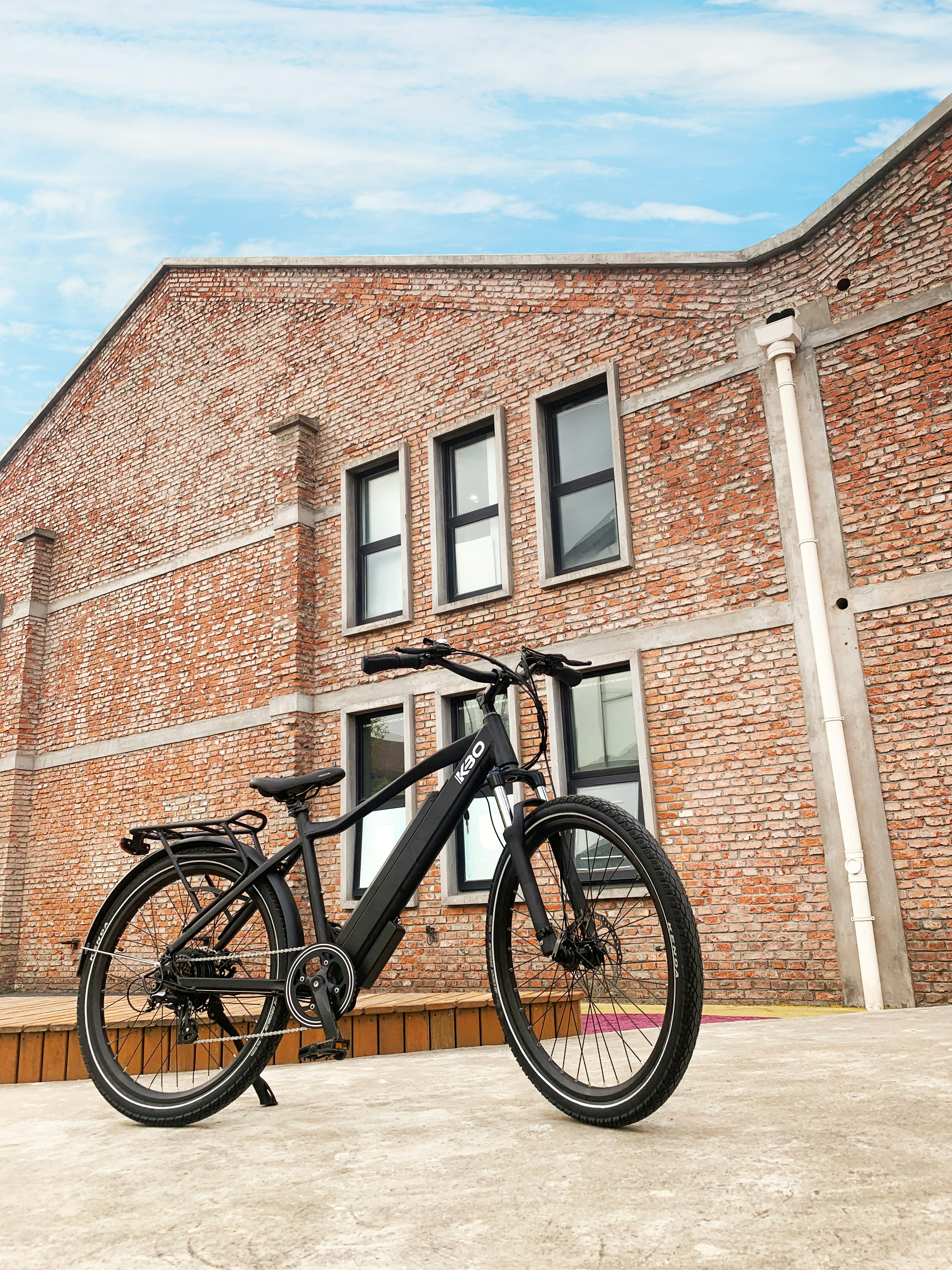 black mountain bike beside brown brick wall